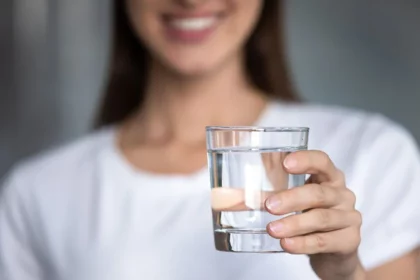 A woman holding a glass of water