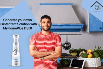 A young Indian man standing in the kitchen with MyHomePlus DSG disinfectant solution spray in the frame.