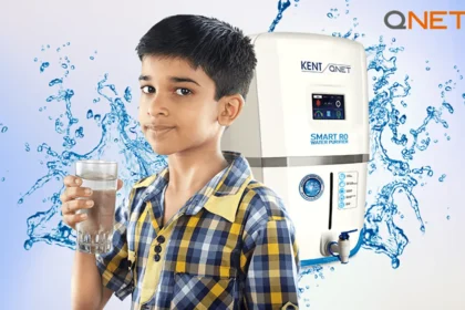 A small child drinking a glass of water with KENT RO in background