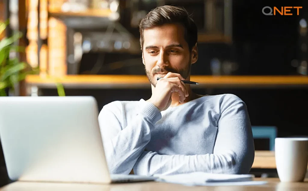 A young entrepreneur comprehending challenges while watching movies for entrepreneurs in front of his laptop