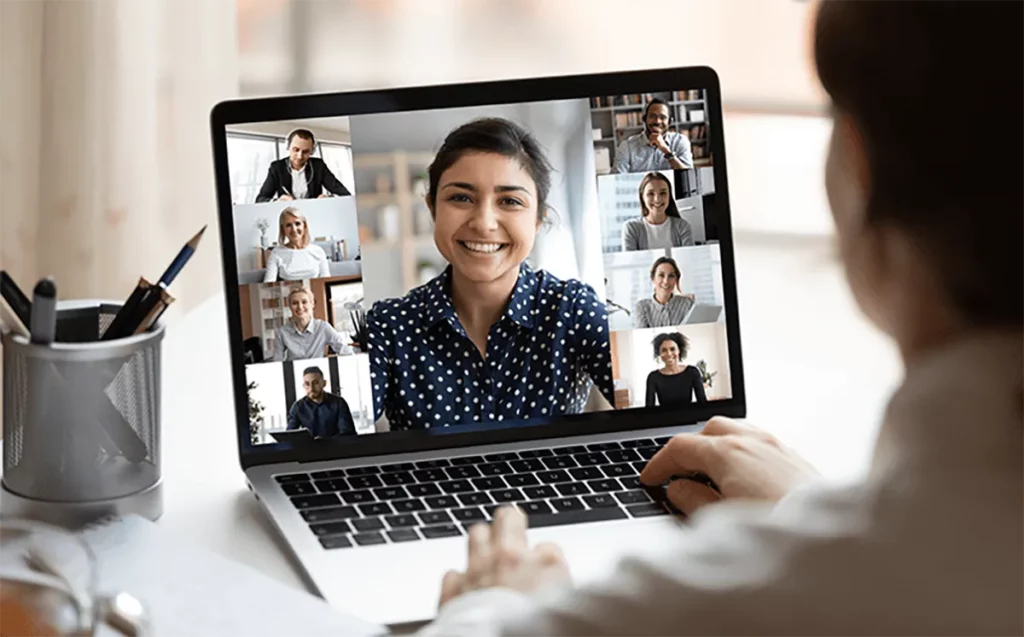 A young woman networking with her sales team in the direct selling industry on a laptop.