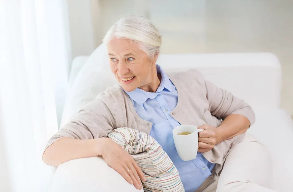 old woman holding a cup of green tea